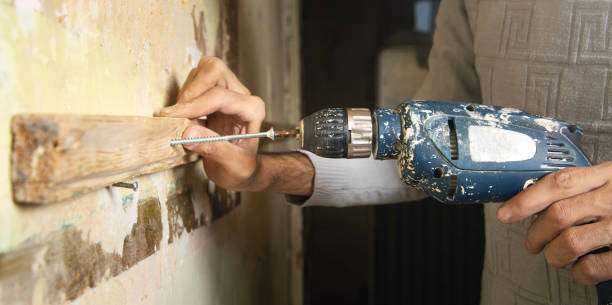Man holds a drill. doing home renovation